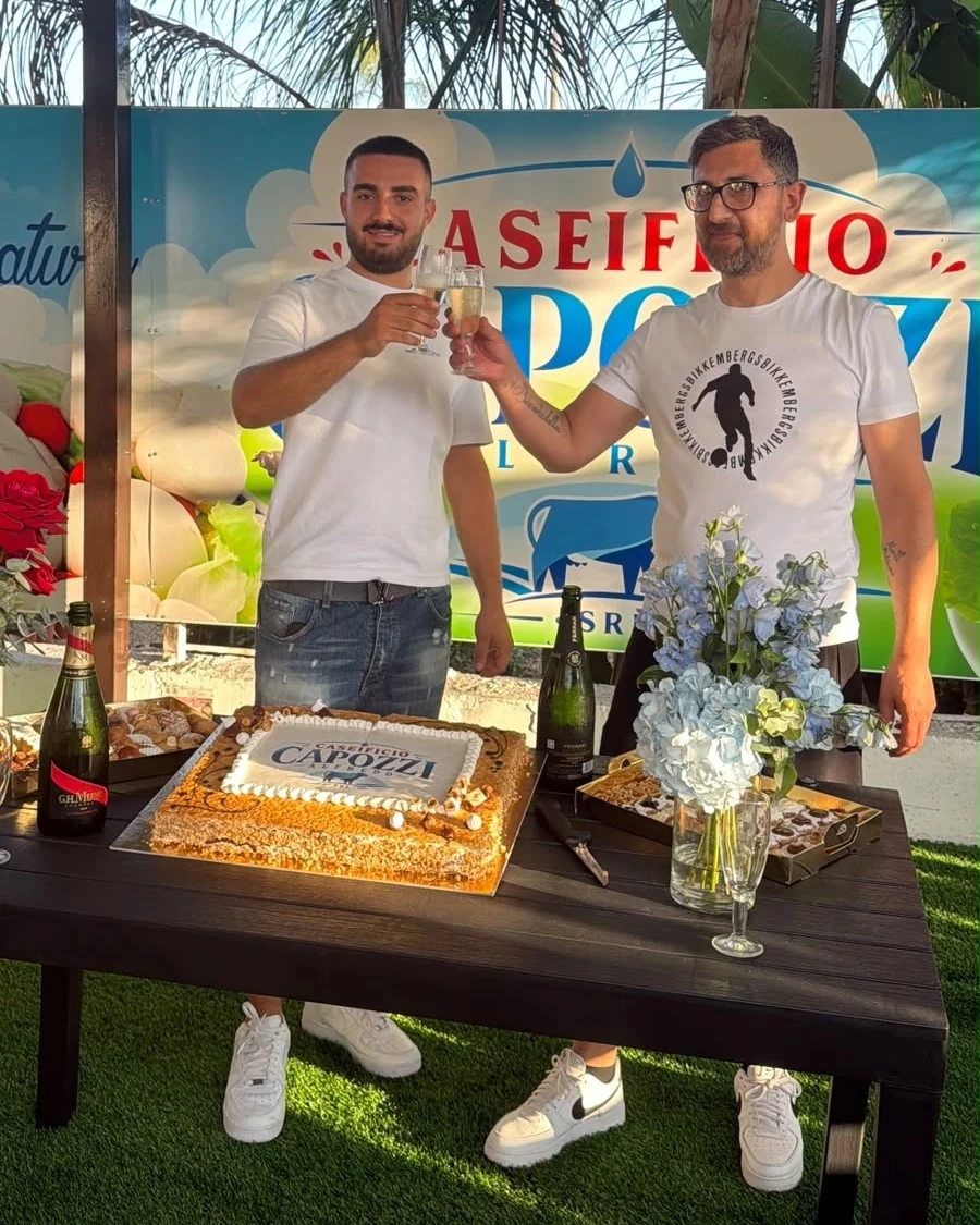 Brindisi sotto il gazebo del punto vendita, davanti all'insegna del Caseificio Capozzi Alfredo