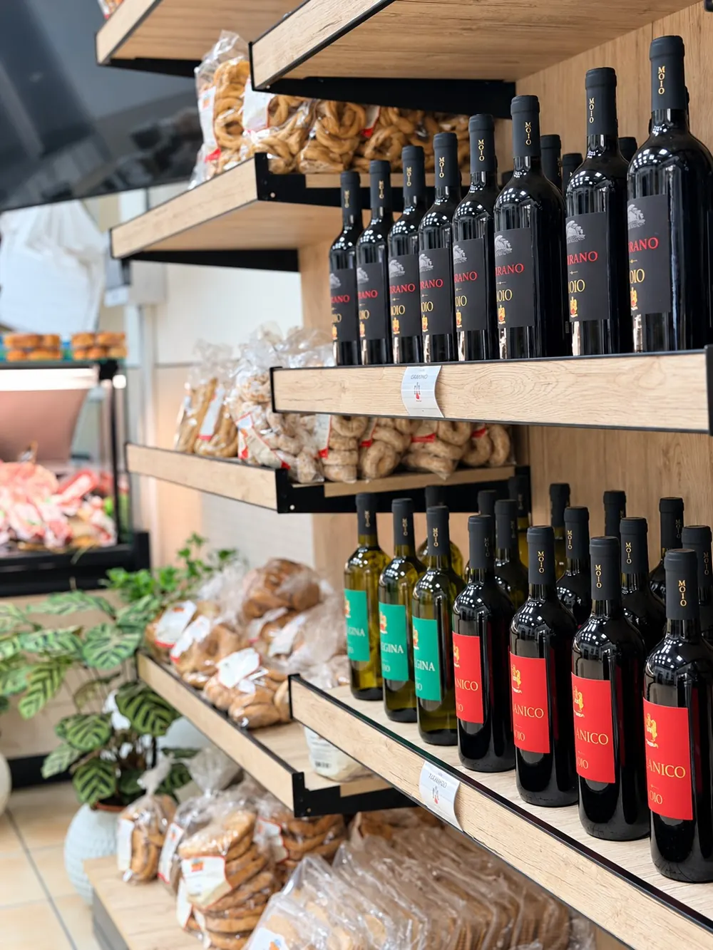 I vini sugli scaffali di legno, con i taralli